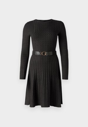 Vestido negro de mangas largas hecho de una tela texturizada con un patrón de diamantes. Presenta un cinturón negro con una hebilla dorada en forma de "G" a la altura de la cintura.