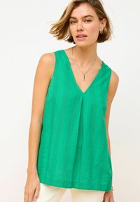 Top senza maniche verde con scollatura a V, strisce testurizzate e vestibilità ampia. Il tessuto appare leggero e liscio.