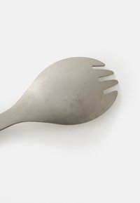 Kovový spork s zaoblenou rúčkou, ktorý má lyžicovú misku a tri hroty. Povrch má matný finish s jemnými škrabancami.