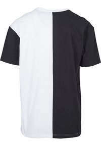 Short-sleeve T-shirt featuring a split design with one half black and the other half white, made of cotton fabric with a smooth texture.