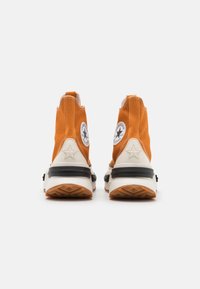Oranžové vysoké tenisky z plátna, s bílým logem hvězdy, černými akcenty, texturovanou gumovou podrážkou a kontrastním šitím.