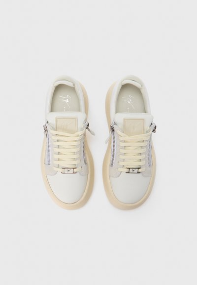 Witte en crèmekleurige leren sneakers met een afgeronde vorm, doorschijnende rubberen zolen en zijritsen. Voorzien van tonale stiksels en een merketiket.