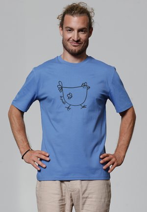 Blauwe katoenen t-shirt met korte mouwen heeft een zwart omlijnd grafisch ontwerp van een kip op de voorkant, met de tekst "le produit."