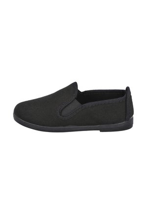 Zapatos negros tipo slip-on con parte superior de lona, acentos elásticos en los laterales, puntera redondeada y suela de goma texturizada. Diseño minimalista sin logotipos visibles.