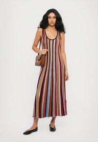 Striped maxi dress featuring a scoop neckline, made from lightweight fabric, in colors including red, blue, and beige, with flared hem.