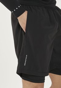 Zwarte hardloopshorts van lichtgewicht stof met een relaxed fit. Bevat zijzakken en het 'ENDURANCE' logo gedrukt op de zoom.