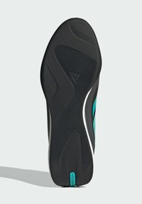 Sort atletisk sko sål med struktureret gummi for greb, med et centralt diamantmønster og teal-detaljer langs siden.