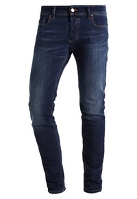 Mörkblå jeans i denim med slim fit. Funktioner inkluderar en klassisk femficksdesign, subtil blekning och kontrasterande sömmar längs sömmarna.