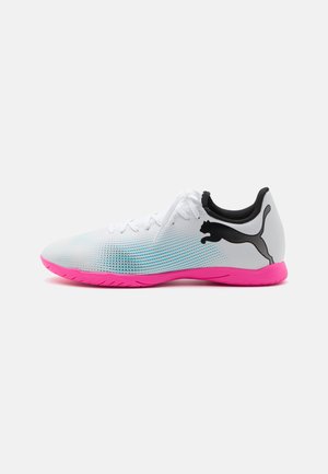 Puma Sportschuhe in Weiß und Pink, mit einem Obermaterial aus Mesh, schwarzen Akzenten und einer strukturierten Sohle, die für Traktion und Flexibilität entwickelt wurde.