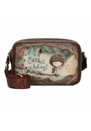 Bolso rectangular marrón con un diseño gráfico que presenta a una chica y texto. Tiene una correa estampada y bordes texturizados. Incluye acentos de herrajes metálicos.