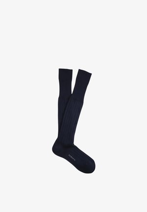 Coppia di lunghi calzini neri a coste con un piccolo logo bianco "PEROFIL" sul piede, mostrati distesi su uno sfondo bianco.