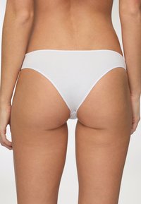 Tanga bianco in cotone con una texture liscia e un design minimalista. Fascia elastica in vita e copertura minimale sul retro.