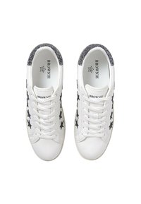 Zapatillas blancas con un patrón de estrellas negras, acentos de purpurina texturizada en el talón y cordones blancos. Material suave con un diseño de puntera redondeada.