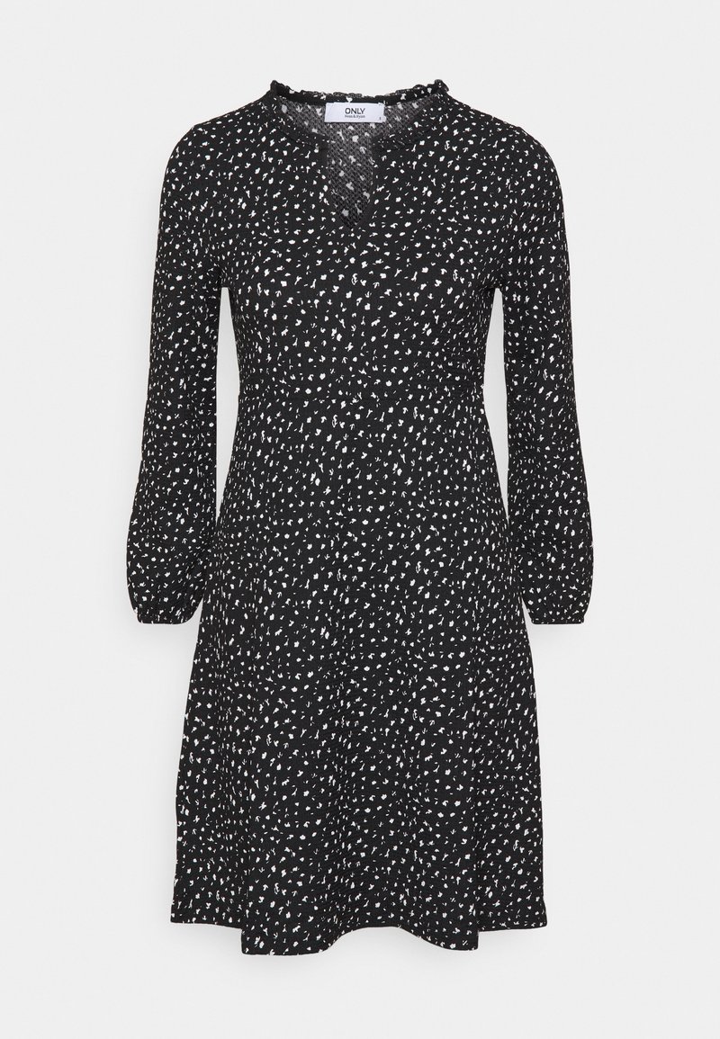Robe noire mi-genou avec des points abstraits blancs, manches longues, taille froncée et petit col en V volanté.