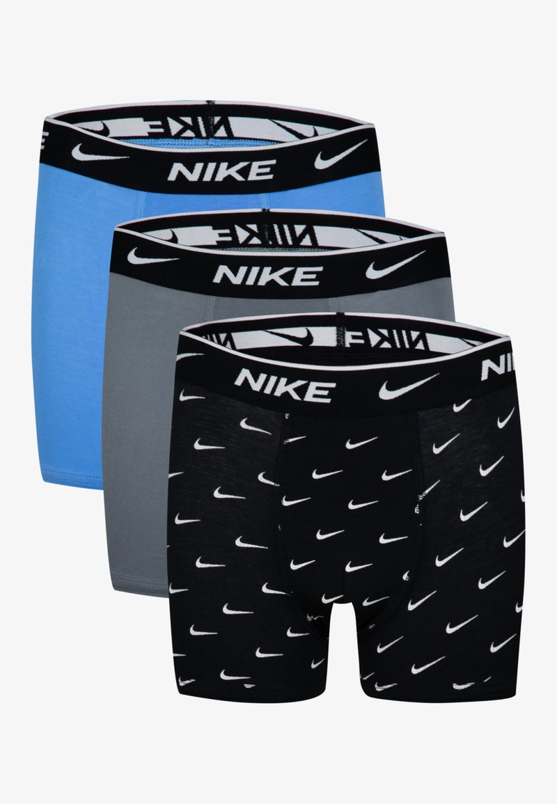 Trīs Nike bokseršortu pāri: viens zilā, viens pelēkā, viens melnā ar baltām Nike logo. Katrai ir melna josta ar logo tekstu.