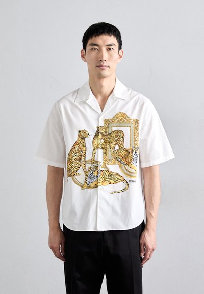 Kortærmet hvid skjorte med et design i guld og dyreprint med leoparder og tigre. Lavet af et let vævet stof med en afslappet pasform.