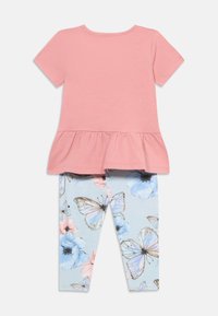 Ροζ τοπ με μανίκια μέχρι τον αγκώνα και βολάν, σε συνδυασμό με ανοιχτό μπλε κολάν που έχουν λουλουδάτο και πεταλούδα μοτίβο, κατασκευασμένα από απαλό βαμβακερό ύφασμα.