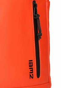 Mochila de color naranja brillante con un acabado texturizado, que cuenta con un bolsillo con cremallera negro y el nombre de la marca "Iam2" impreso en negro en el lateral.