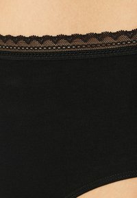 Culotte en coton noir avec un délicat lacet au niveau de la taille, offrant une texture lisse et une silhouette classique.