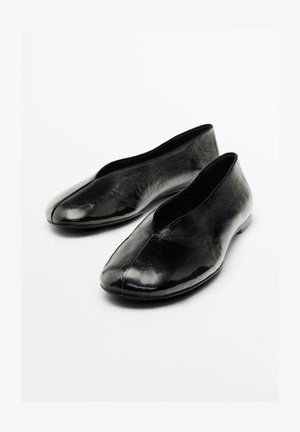 Black ballerina-style shoes made of glossy leather, featuring a seamless design with a low-cut front and rounded toe.