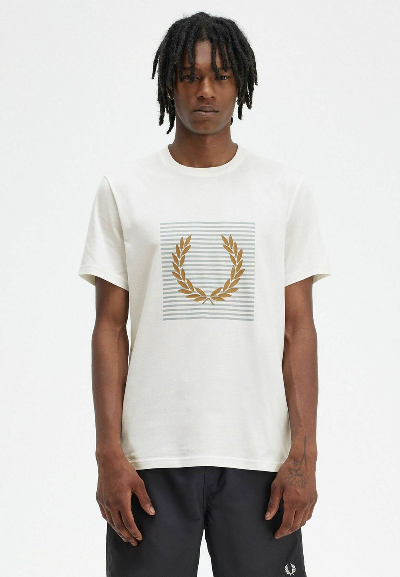 Camiseta de algodón blanca con un gráfico central de hojas de laurel doradas sobre un fondo gris a rayas. Mangas cortas, cuello redondo.
