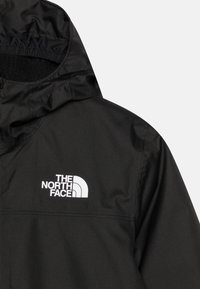 Veste à capuche noire avec un tissu lisse et résistant à l'eau, et un logo blanc sur la poitrine. Design simple avec une ouverture de capuche élastiquée.