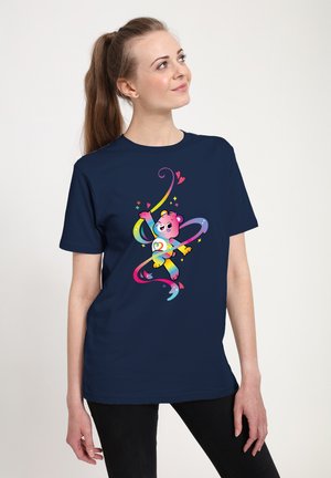 T-shirt bleu marine avec un personnage de dessin animé d'ours coloré aux accents roses et des rubans arc-en-ciel en spirale, sur fond uni.