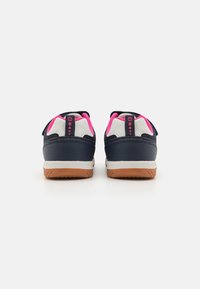 Marineblauwe en witte sneakers met roze accenten, klittenbandsluiting, rubberen zool en een gestructureerde hiel, ontworpen voor comfort en gebruiksgemak.