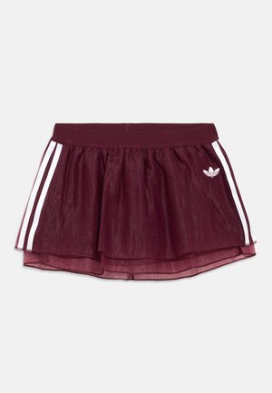 Bordowa spódnica Adidas z przezroczystą nakładką, białe boczne paski, elastyczny pas i małe białe logo Adidas z przodu po prawej stronie.