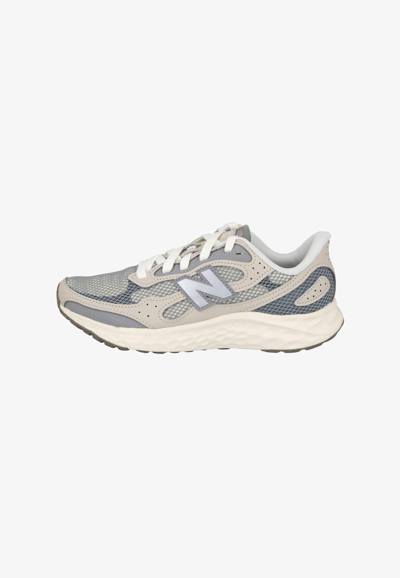 Zapatilla deportiva ligera en malla gris y beige, con una suela de goma texturizada, una marca destacada y cordones blancos en contraste.