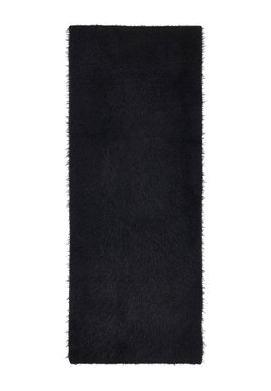 Tapis rectangulaire noir à poils longs avec une texture douce et moelleuse et des bords légèrement effrangés sur fond blanc.