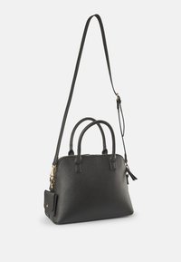 Černá texturovaná kožená kabelka s dvojitými uchy, odnímatelným dlouhým ramenním popruhem, zlatým zipem a malou připevněnou kapsičkou na mince na bílém pozadí.