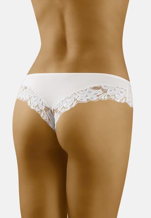 String en dentelle blanche, orné de dentelle sur l'arrière, mettant en avant un design sans coutures avec un tissu doux.