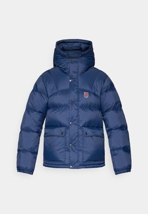 Námořnická puffer bunda s kapucí, se zapínáním na zip, patentkami a dvěma předními kapsami. Hladká, lesklá textura se šitými panely.