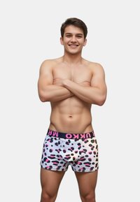 Herrarnas boxer kalsonger i vitt med rosa och svarta abstrakta fläckar, med en svart midjeelastisk med rosa text. Mjuk bomullsmaterial, figurnära design.