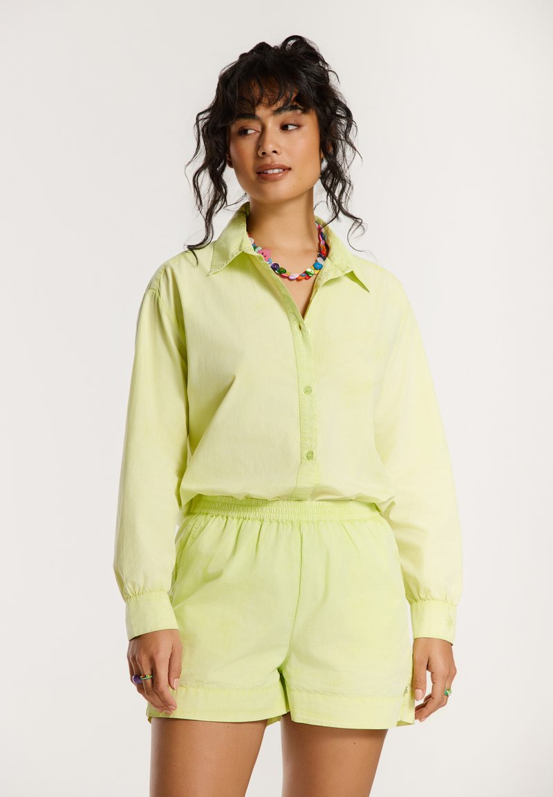 Lichtgroen katoenen shirt met lange mouwen en knoopsluiting aan de voorkant, gecombineerd met bijpassende shorts. Heeft een elastische tailleband en een casual pasvorm.