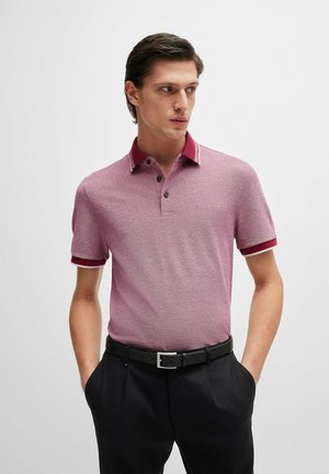 Polo shirt in lichtrood met een gestructureerde weving, contrasterende donkerrode kraag en manchetten, een drukknoopsluiting met drie knopen en een geborduurd logo op de borst.
