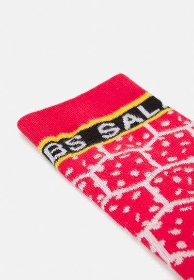 Calcetín multicolor con una base rosa y patrones blancos, una banda negra con el texto "OFERTA" y acentos amarillos en la parte superior. Textura de punto suave.