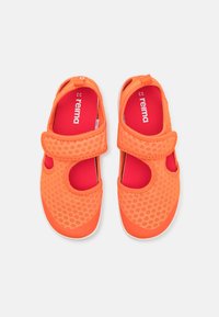 Jasnopomarańczowe buty dziecięce z teksturowanej siateczki, o zaokrąglonym kształcie, z rzepem i wyściółką w kolorze czerwonym.