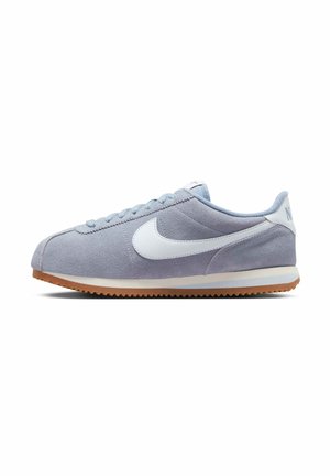 Sneaker Nike in camoscio azzurro chiaro con logo bianco, suola in gomma e chiusura con lacci, vista di lato su sfondo bianco.