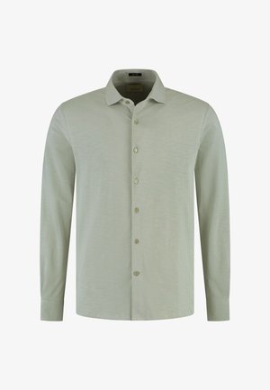 Lichtgroene blouse met lange mouwen, knoopsluiting, klassieke kraag en klein geborduurd logo op de linkerborst.