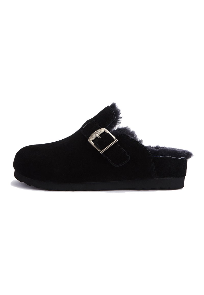 Black suede clog with a fuzzy lining, adjustable buckle strap, round toe, and textured rubber sole. Simple design and clean edges.