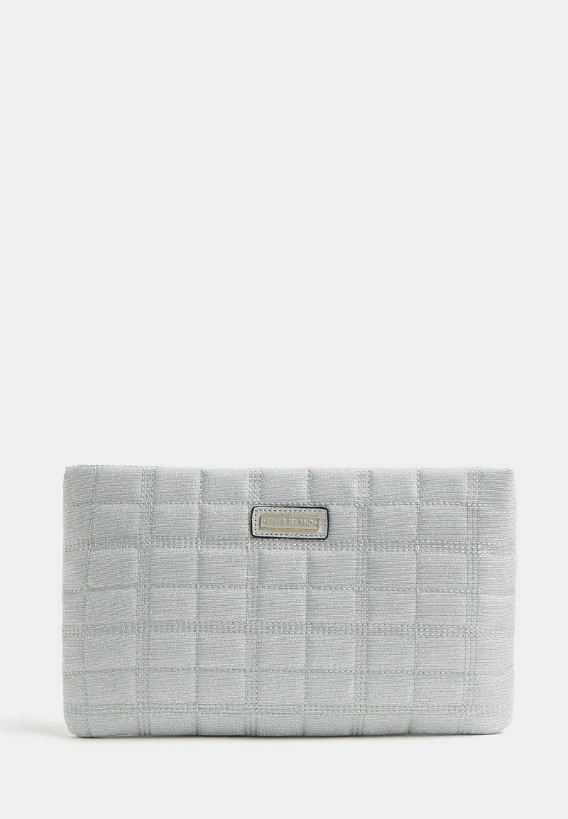 Pochette matelassée gris clair en tissu texturé, de forme rectangulaire, avec une plaque logo en métal au centre. Pas de quincaillerie ou d'accents visibles.