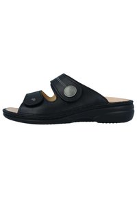 Zwarte leren slipper sandalen met een open teen, voorzien van een ronde zilveren accent en verstelbare banden. Zachte binnenvoering en duurzame zool.