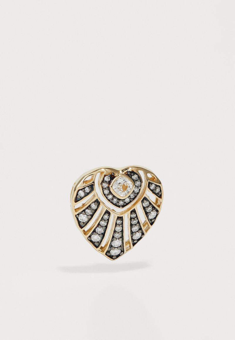 Χρυσό δαχτυλίδι σε σχήμα καρδιάς με κεντρικό διαμάντι και γύρω μαύρες και λευκές πέτρες; διαθέτει ακτινωτές γραμμές και γυαλιστερή φινίρισμα.