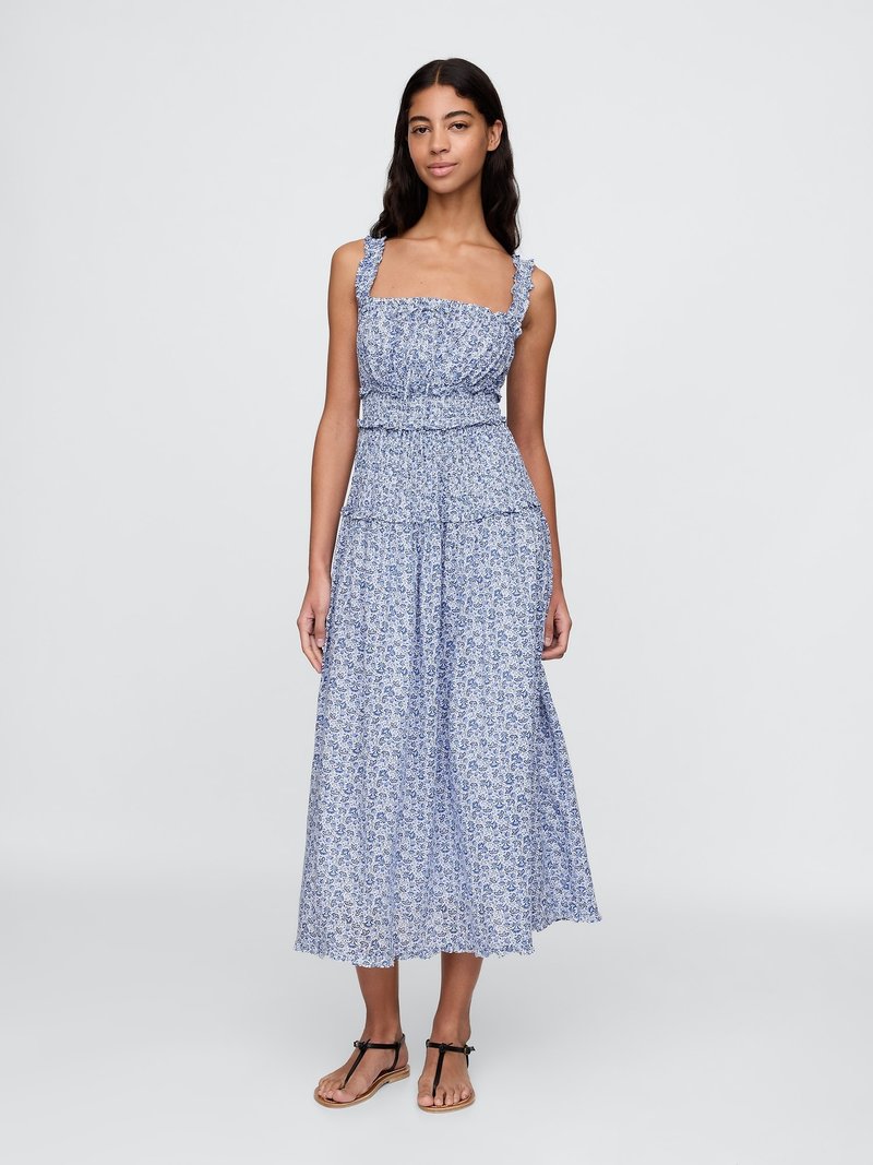 Blå blomstret maxikjole med volangstropper, tætsiddende bodice og lagdelt nederdel. Letvægts stof, med små blomstermønstre.