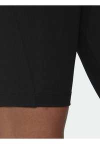 Svarta ribbade shorts i en nära passform, med en slät fåll och minimal sömdetalj för ett elegant utseende.