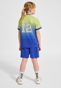 Ungdomsidrottströja och shorts set i gradient från grön till blå. Tröjan har nummer 12 och kontrasterande blå detaljer. Strumporna har ett svart chevronmönster.