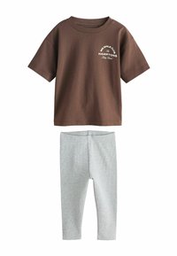 Brown cotton T-shirt with short sleeves, featuring "BIG SMILE CLUB The HAMPTONS" print. Grey ribbed leggings, form-fitting with a smooth texture.