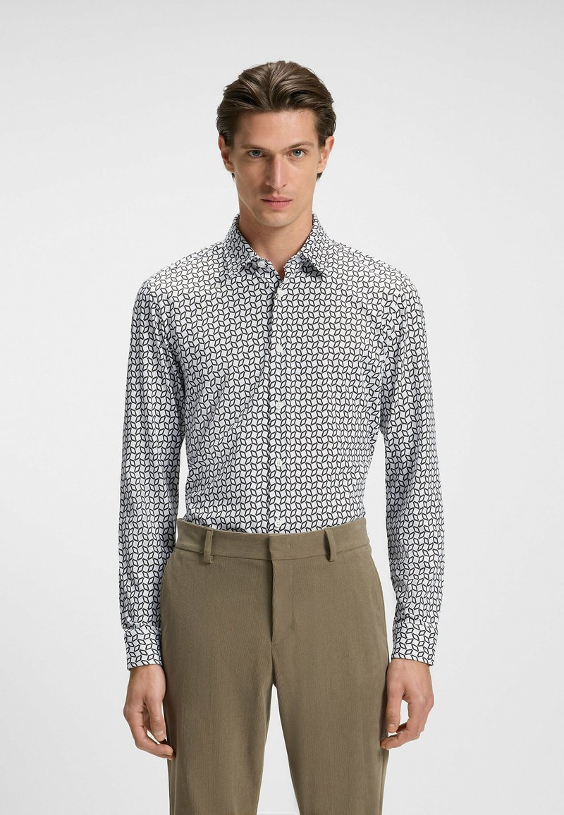 Witte langemouwen shirt met zwart geometrisch patroon, met knoopsluiting en een slim fit, gecombineerd met lichte beige broek.